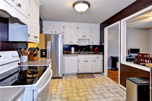 kitchen featuring tasteful backsplash, white appliances, a sink, and white cabinets