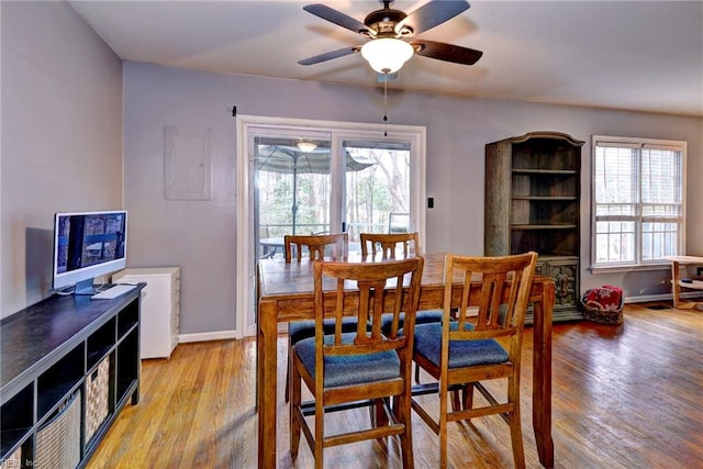 dining area featuring light wood finished floors, a ceiling fan, and baseboards