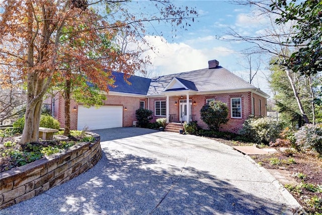 view of front facade with driveway, a garage, a chimney, and brick siding