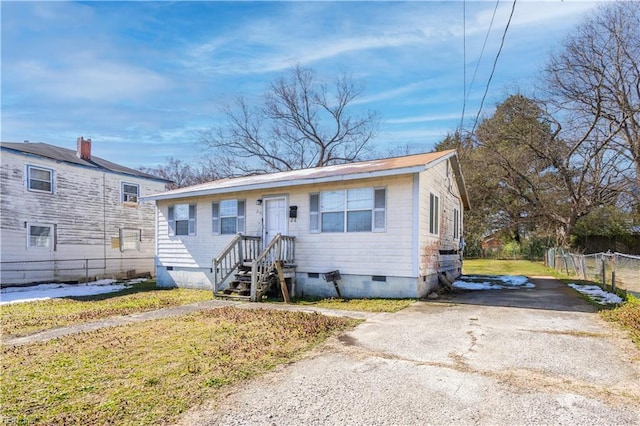 bungalow-style house featuring a front lawn, crawl space, and fence