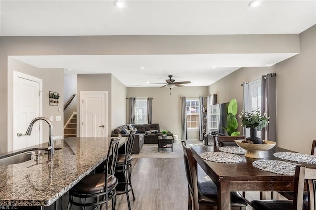 dining room featuring stairway, dark wood finished floors, a ceiling fan, and recessed lighting