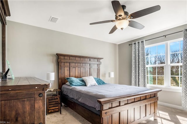 bedroom with ceiling fan, visible vents, baseboards, and light colored carpet