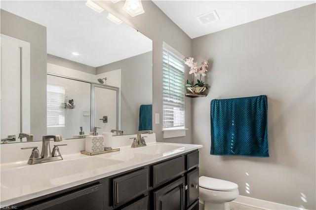 full bath featuring a stall shower, a sink, toilet, and baseboards