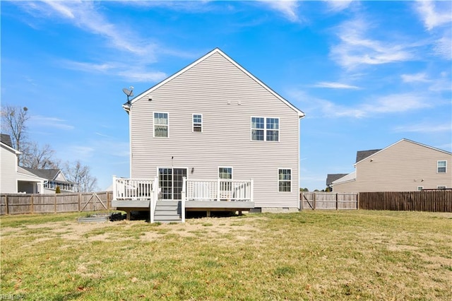 rear view of property featuring a deck, a yard, and a fenced backyard