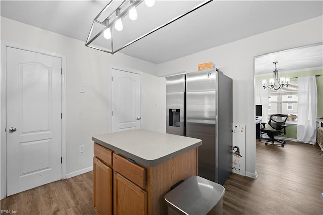 kitchen with dark wood-style flooring, baseboards, stainless steel refrigerator with ice dispenser, a center island, and brown cabinetry