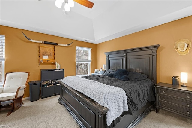 bedroom featuring lofted ceiling, ceiling fan, multiple windows, and light colored carpet