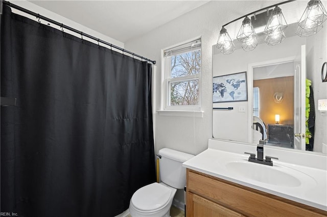 bathroom featuring curtained shower, a textured wall, vanity, and toilet