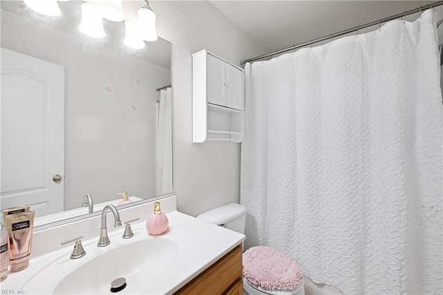 bathroom with toilet, a notable chandelier, and vanity