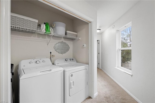 clothes washing area featuring laundry area, washing machine and dryer, baseboards, and light colored carpet