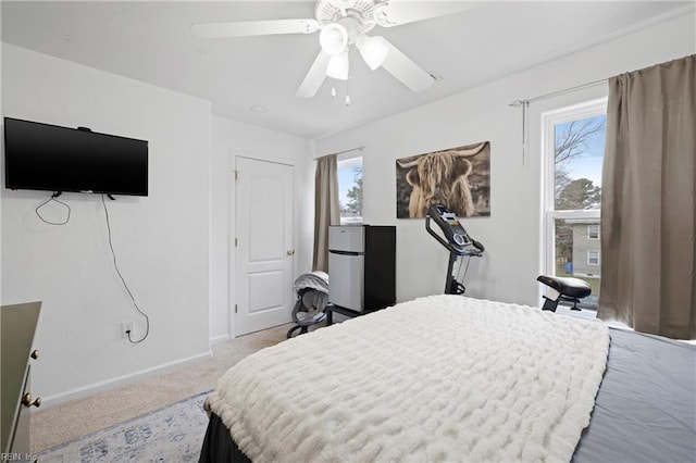 bedroom with light colored carpet, ceiling fan, and baseboards