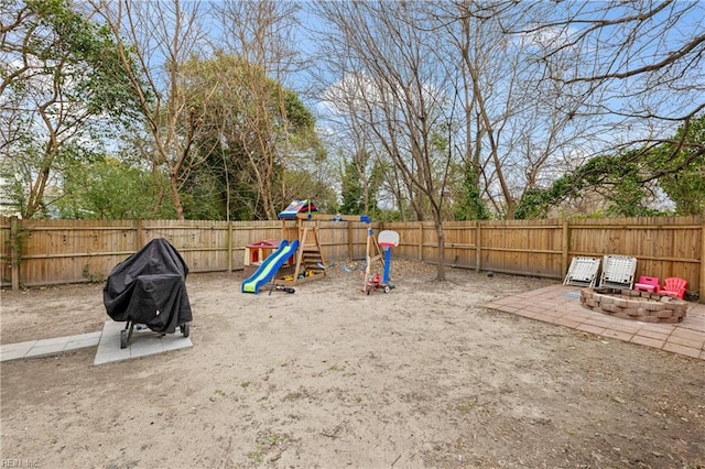 view of play area with a fire pit, a patio area, and a fenced backyard