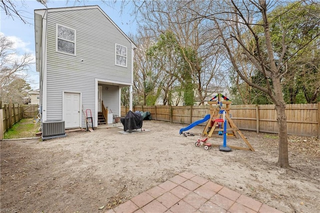 back of house featuring entry steps, a playground, a fenced backyard, and central air condition unit