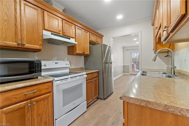 kitchen featuring appliances with stainless steel finishes, light countertops, a sink, and under cabinet range hood