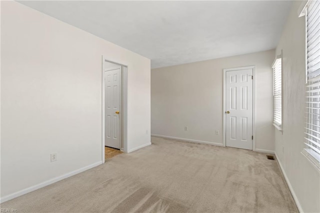 unfurnished bedroom with baseboards and light colored carpet