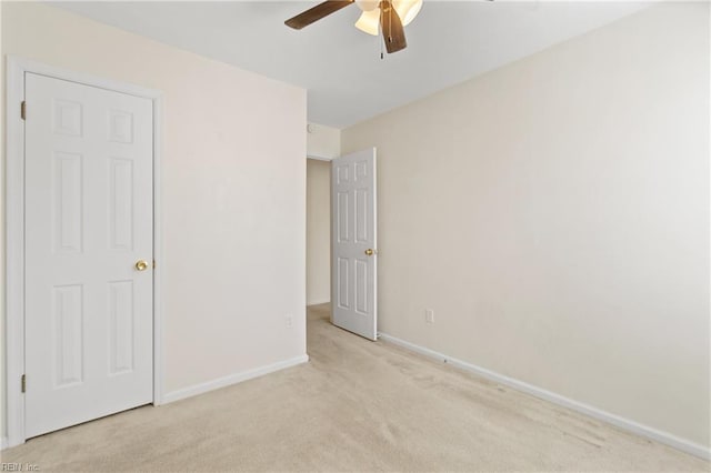 unfurnished bedroom featuring light carpet, ceiling fan, and baseboards