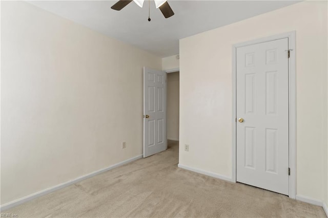 unfurnished bedroom featuring light carpet, ceiling fan, and baseboards