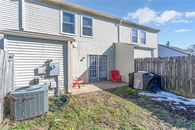 back of house featuring cooling unit, a patio area, fence, and a lawn