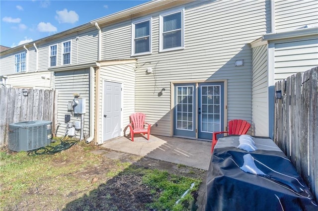 rear view of property featuring central air condition unit, fence, and a patio