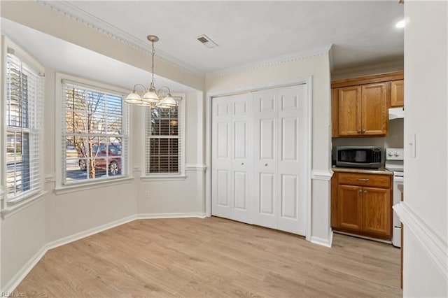 unfurnished dining area with ornamental molding, visible vents, light wood-style flooring, and an inviting chandelier