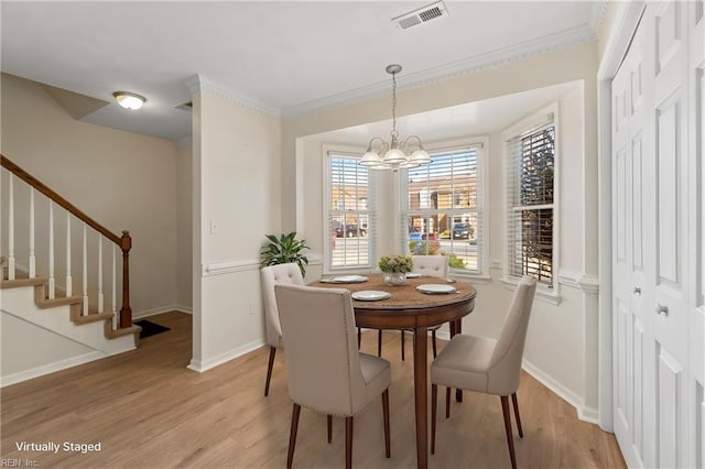 dining room featuring stairway, visible vents, light wood-style floors, and an inviting chandelier