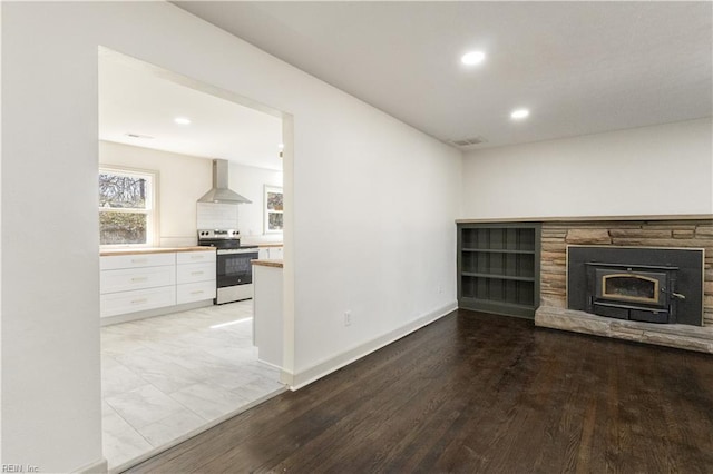 unfurnished living room featuring a stone fireplace, recessed lighting, visible vents, baseboards, and light wood-style floors