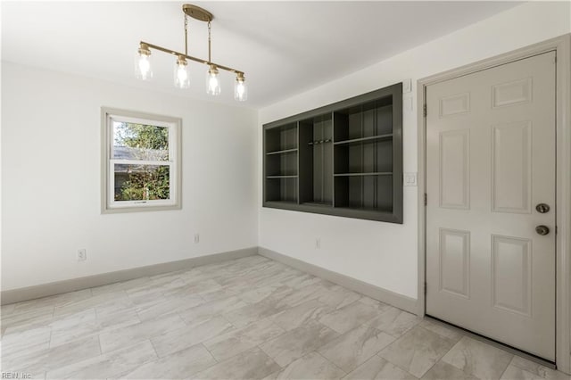 unfurnished dining area featuring baseboards