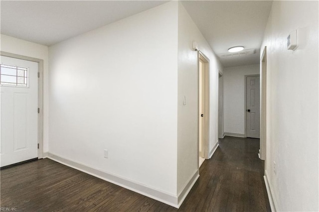 foyer entrance featuring baseboards and dark wood-type flooring