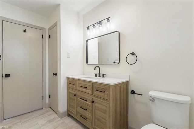 bathroom with toilet, a closet, and vanity