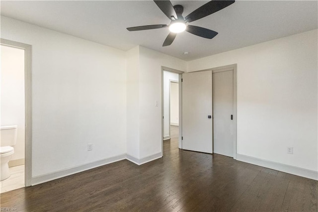 unfurnished bedroom with ensuite bathroom, ceiling fan, baseboards, a closet, and dark wood finished floors