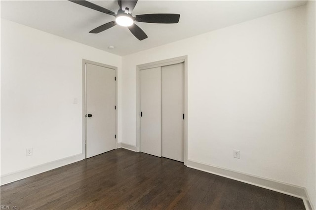 unfurnished bedroom with a ceiling fan, a closet, dark wood finished floors, and baseboards