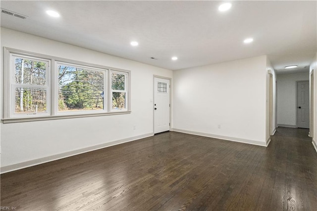 spare room with dark wood-style floors, plenty of natural light, visible vents, and recessed lighting