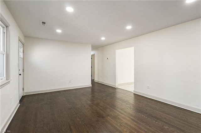 spare room featuring baseboards, visible vents, dark wood finished floors, and recessed lighting