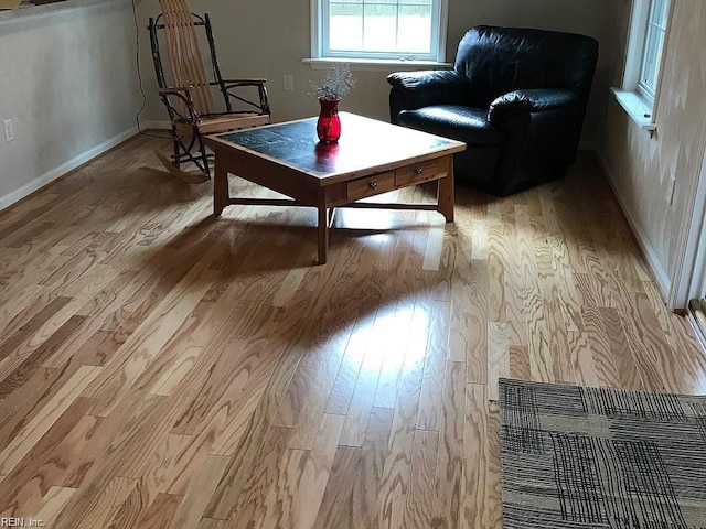 sitting room featuring baseboards and light wood-style floors