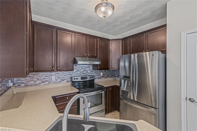 kitchen with under cabinet range hood, stainless steel appliances, a sink, dark brown cabinets, and light countertops