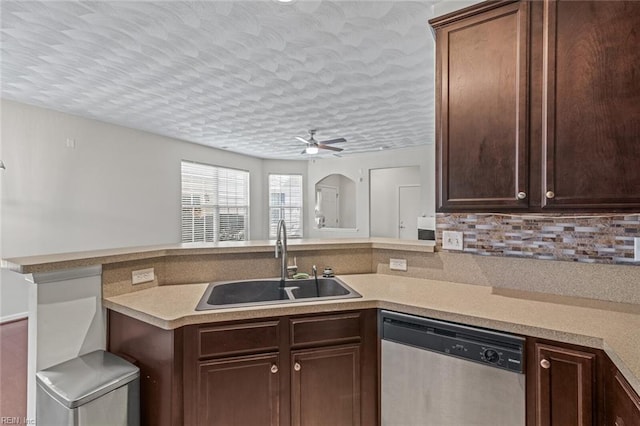 kitchen featuring a sink, a peninsula, light countertops, and dishwasher