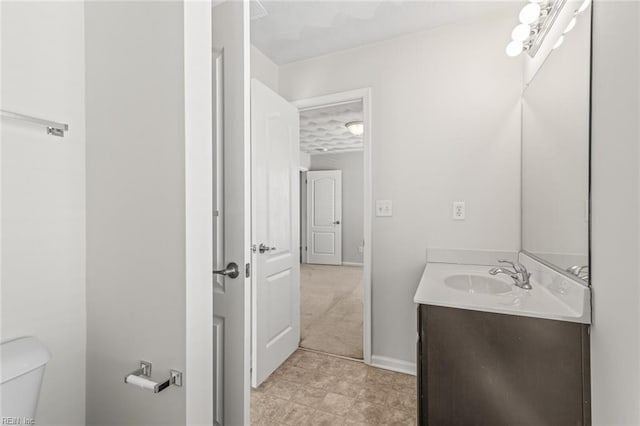 half bath with vanity, toilet, and baseboards