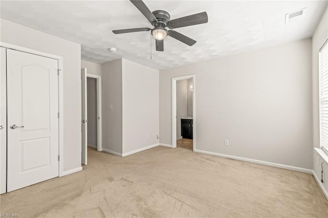 unfurnished bedroom featuring ceiling fan, connected bathroom, carpet flooring, visible vents, and baseboards