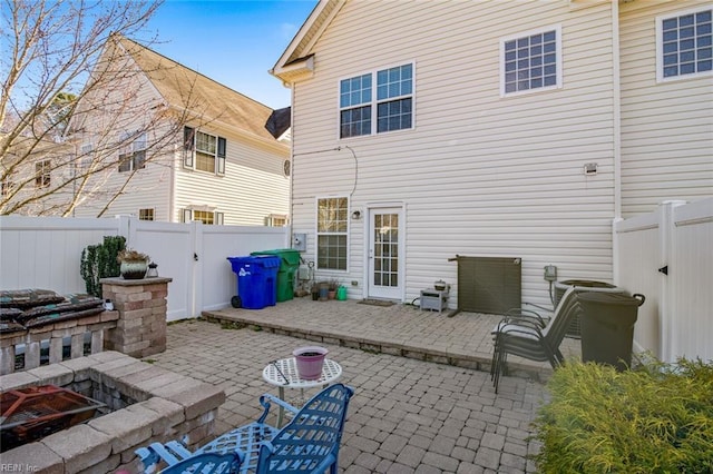 back of property with a patio area, a fire pit, and a fenced backyard