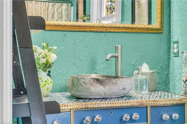 interior details featuring a textured wall and vanity