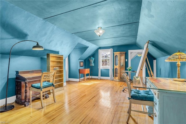 bonus room featuring lofted ceiling, light wood-style flooring, and baseboards