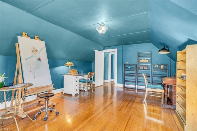 office area featuring lofted ceiling, baseboards, and hardwood / wood-style floors