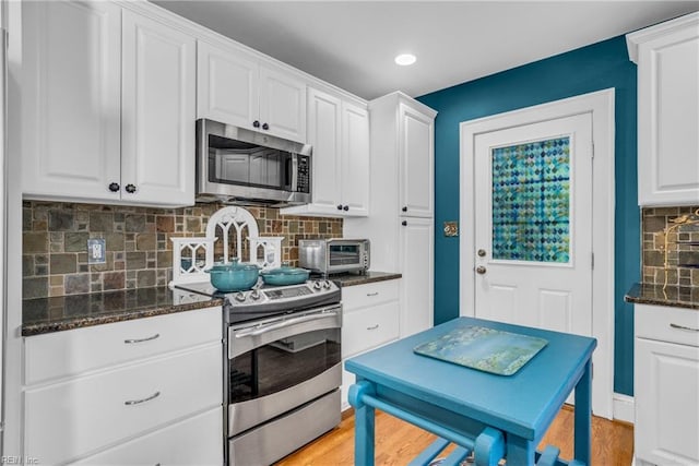 kitchen with light wood-style floors, a toaster, appliances with stainless steel finishes, and white cabinets