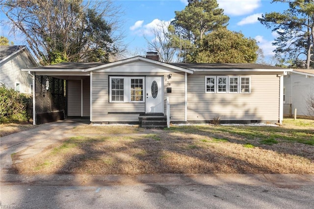 view of front of property featuring a carport, crawl space, a chimney, and driveway