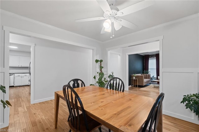 dining room with ornamental molding, light wood-type flooring, baseboards, and a ceiling fan