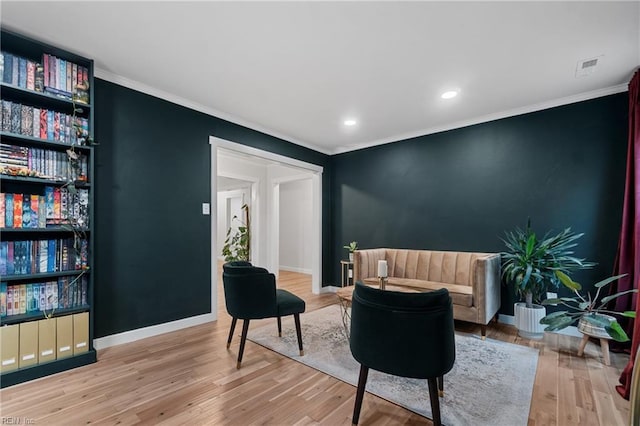 living area featuring ornamental molding, wood finished floors, visible vents, and baseboards