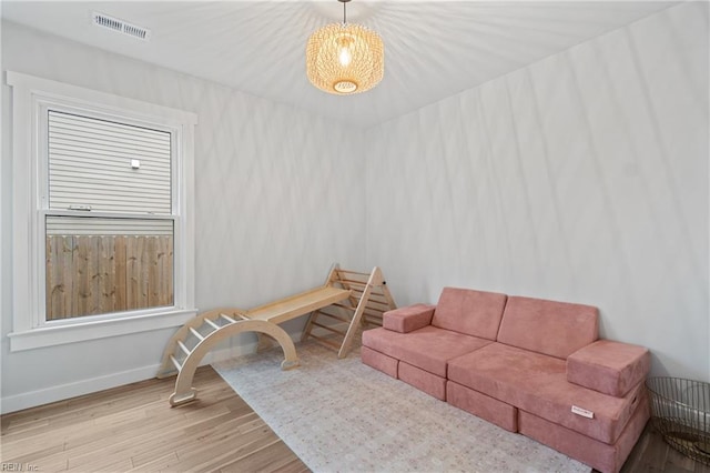 living room featuring baseboards, visible vents, and wood finished floors