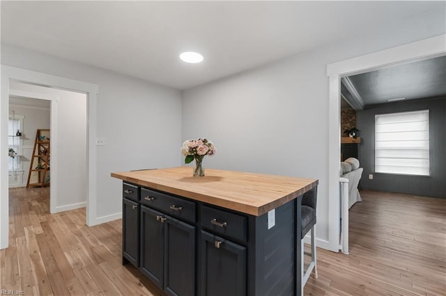 kitchen featuring butcher block countertops, a breakfast bar, and light wood-style floors