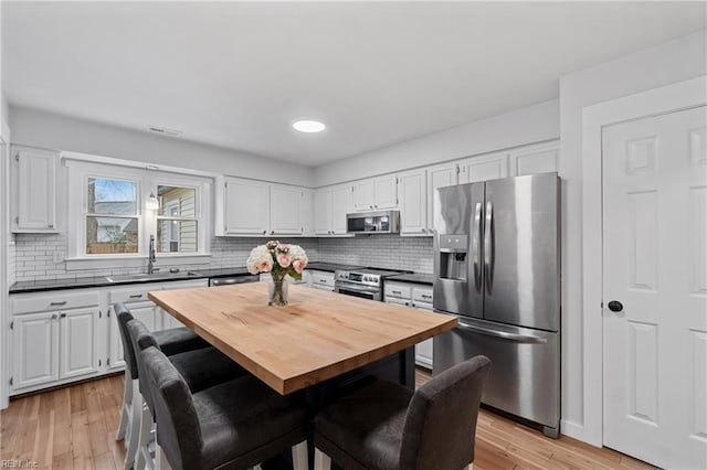 kitchen with appliances with stainless steel finishes, a sink, and white cabinets