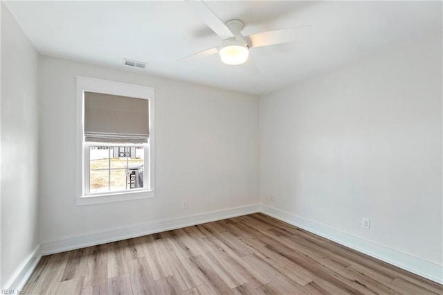 spare room with a ceiling fan, baseboards, visible vents, and wood finished floors