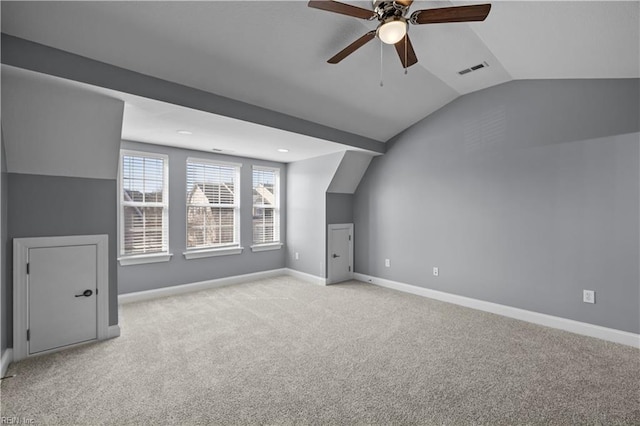 bonus room featuring light carpet, lofted ceiling, visible vents, and baseboards